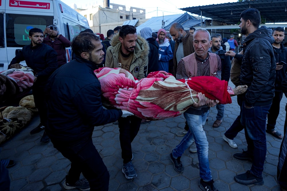 Palestinians carry the body of a relative killed in the Israeli occupation bombardment of the Gaza Strip at a hospital in Deir al-Balah, palestine, Dec. 15, 2024. (AP)