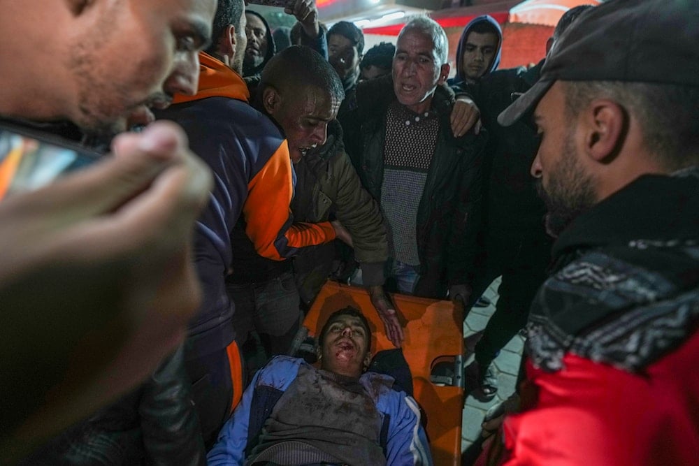 An injured man is carried into the Al-Aqsa Martyrs hospital in Deir al-Balah after an Israeli army strike in the Bureij refugee camp, central Gaza Strip, on December 14, 2024. (AP)