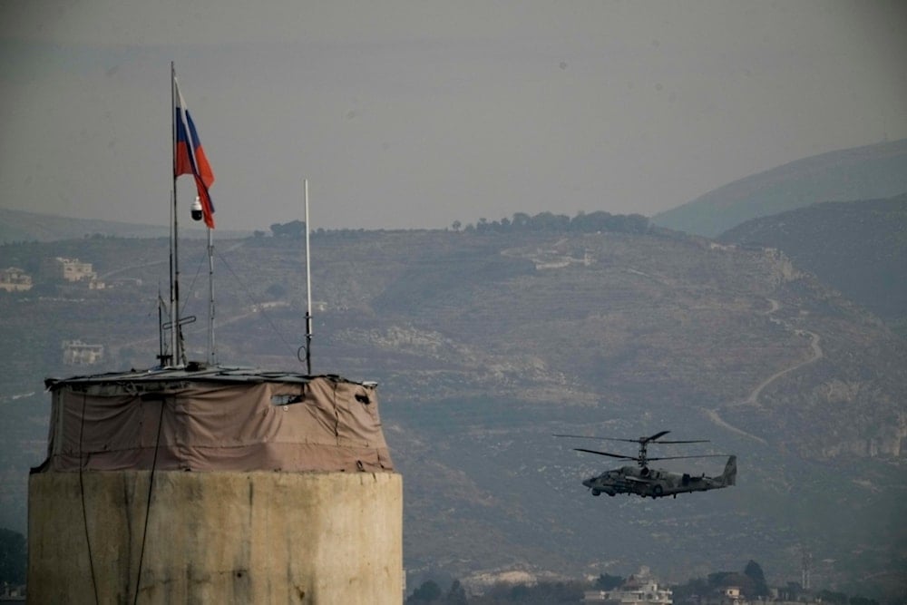 A Russian helicopter flies over the Hmeimim Air Base, a Syrian airbase currently operated by Russia, located southeast of the city of Latakia in the town of Hmeimim, Syria, on Monday, December 16, 2024 (AP)