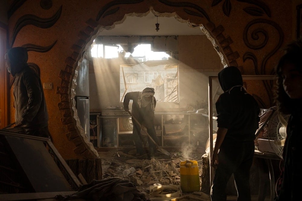 Palestinians look at their neighbor's damaged house following an Israeli strike in Rafah, southern Gaza Strip, January 27, 2024 (AP)