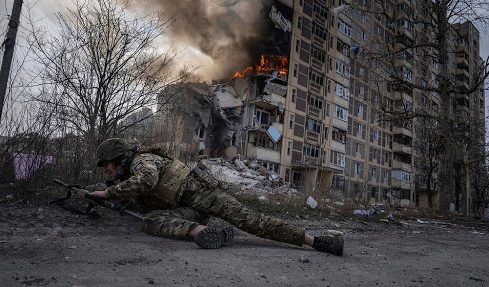 A Ukrainian police officer takes cover in front of a burning building that was hit in a Russian airstrike in Avdiivka, Ukraine, Friday, March 17, 2023. (AP)