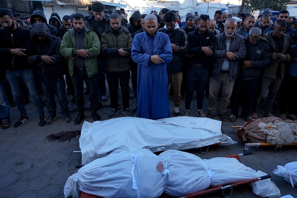 Palestinians pray next to the bodies of their relatives killed in the Israeli bombardment of the Gaza Strip, at a hospital in Deir al-Balah, Sunday, Dec. 15, 2024. (AP)