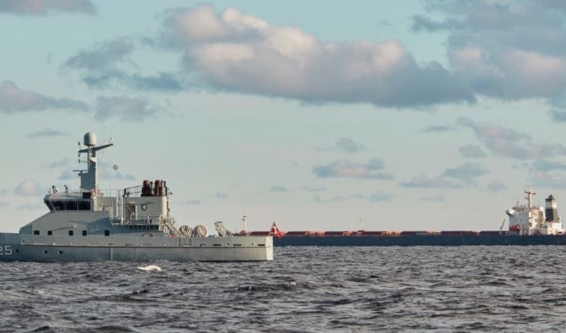   The Chinese carrier Yi Peng 3, in the background, is monitored by a Danish naval patrol vessel in the Sea of Kattegat, off the coast of Jutland, Denmark, 20 November 2024. (AP)