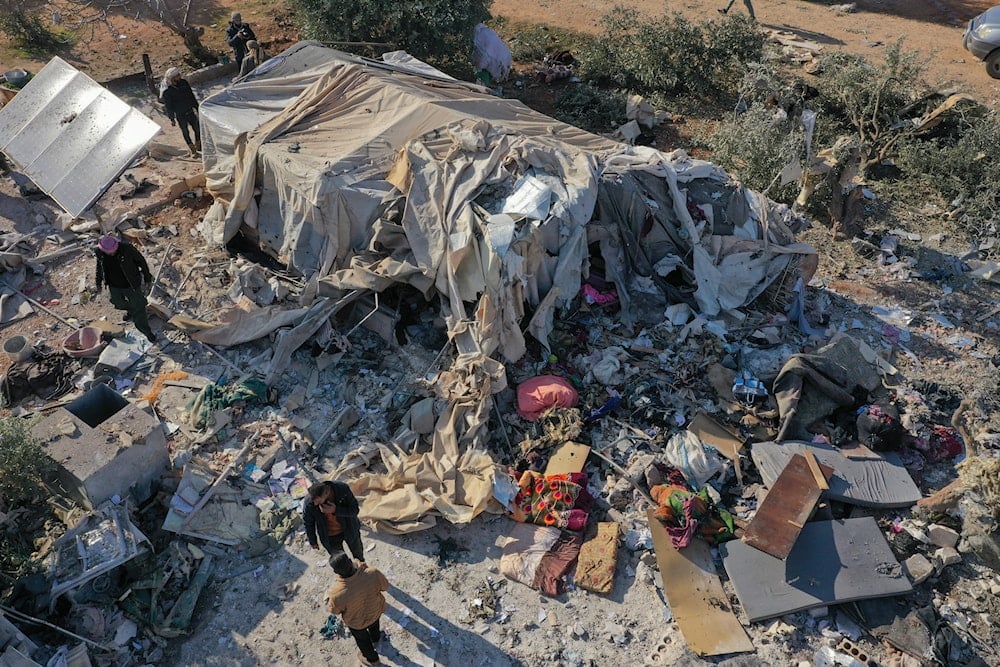 People inspects a camp for internally displaced people destroyed during an airstrike near the village of Harbnush, north of Idlib, Syria, on December 2, 2024. (AP)