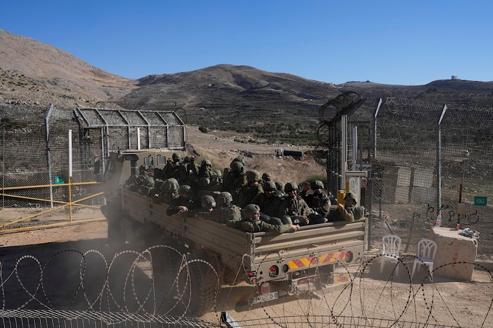 Israeli soldiers stand on an armoured vehicles before crossing the security fence, moving towards the so-called Alpha Line that separates the Israeli-controlled Golan Heights from Syria, in the town of Majdal Shams, on December 18, 2024. (AP)