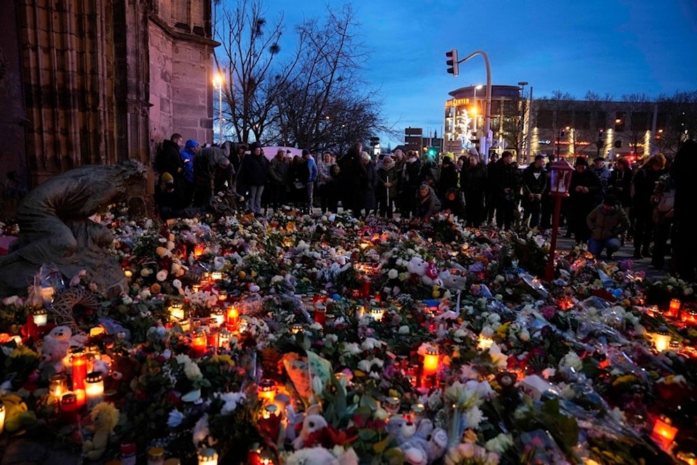 Citizens pay tribute for deaths outside St. John's Church near a Christmas Market, where a car drove into a crowd on Friday evening, in Magdeburg, Germany, Saturday, Dec. 21, 2024. (AP)