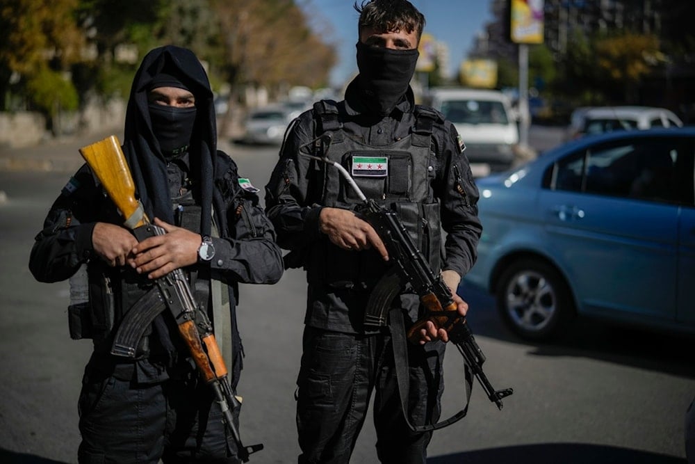 Two Syrian fighters pose for the photographer as they patrol in downtown Damascus, Syria, Dec. 19, 2024. (AP)