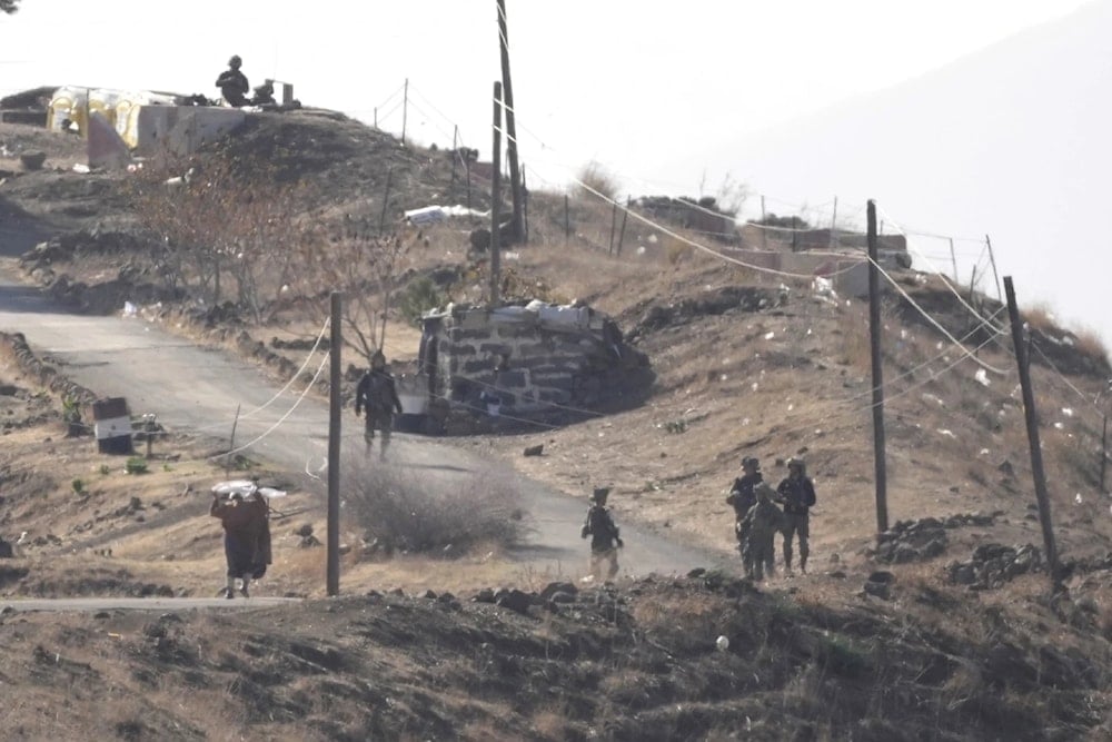 A Syrian man left waves a white flag as he approaches Israeli occupation forces in Maaria village on Thursday December 19,2024.(AP)