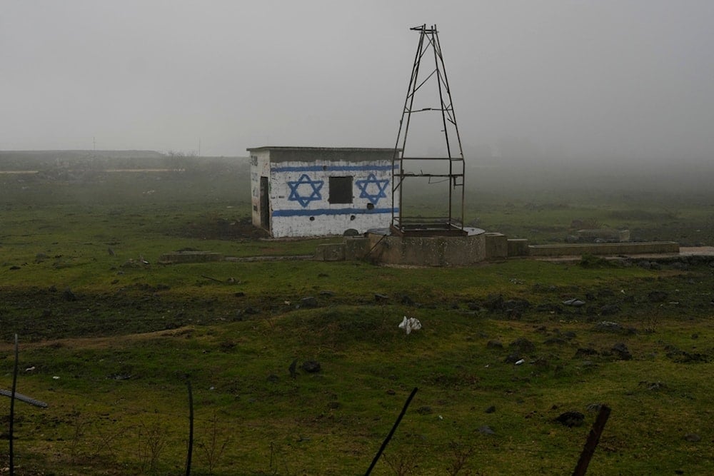 A house painted with the colors of the Israeli flag is seen next to a road in the Israeli-controlled Golan Heights, on a foggy Sunday, Dec. 22, 2024. (AP Photo/Matias Delacroix)