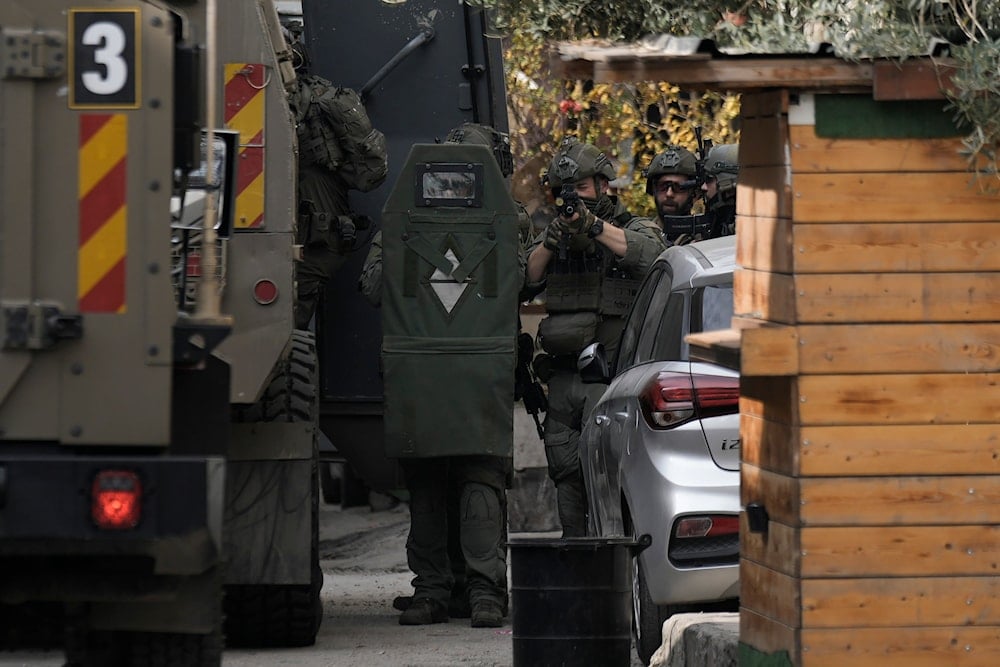 Israeli soldiers are seen during an army raid, following a car that was hit by bullets in which a Palestinian was reportedly killed by Israeli special force, in the occupied West Bank city of Qalqilya, on December 12, 2024. (AP)