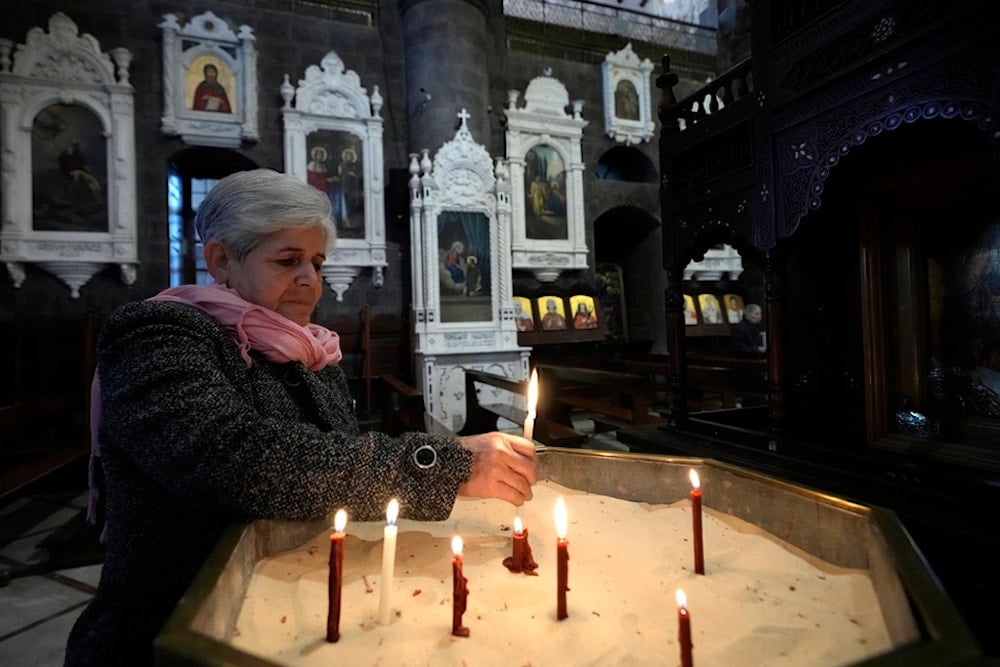 A Syrian woman lights a candle inside a church during the first Sunday Mass since Syrian President Bashar Assad's ouster, in old Damascus, Syria, Sunday, Dec. 15, 2024. (AP)