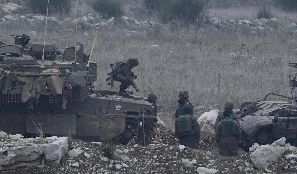 An Israeli soldier stands on the top of a tank next to a Syrian tank inside the buffer zone, on Saturday, Dec. 21, 2024. (AP)