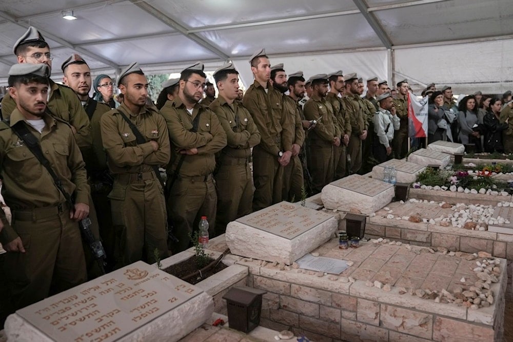 Israeli soldiers pay their respects on the graves of comrades after the funeral of Staff Sgt. Zamir Burke, 20, at Mount Herzl military cemetery in occupied al-Quds, occupied Palestine, Sunday, November 1, 2024 (AP)