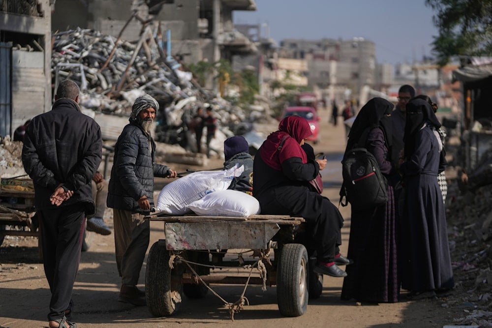 Palestinians carry UN donated flour in Khan Younis, central Gaza Strip, on December 14, 2024.(AP )