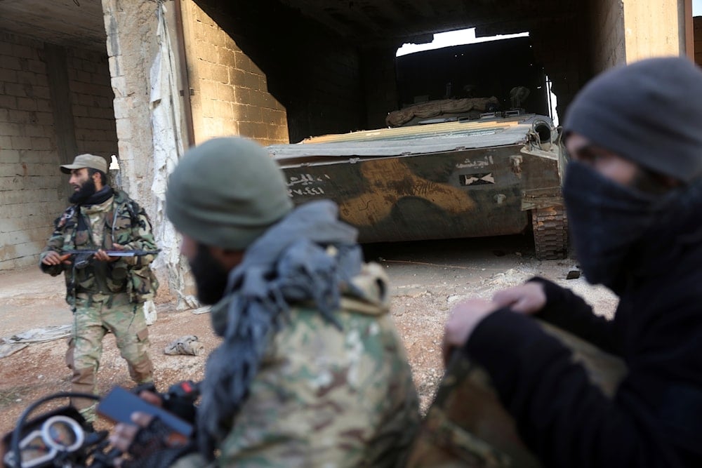 Syrian opposition fighters ride in front of a tank they allegedly captured from Syrian Government troops in Talhiya, Idlib countryside, Syria, on November 29, 2024. (AP)