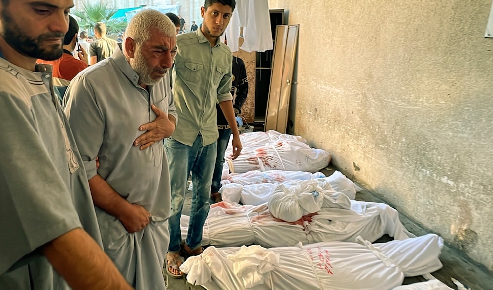 A Palestinian man cries over the body of a relative as bodies of those killed by Israeli airstrikes on Jabalia refugee camp are lined up, at the Indonesian hospital, northern Gaza Strip, Saturday, Nov. 18, 2023. (AP)