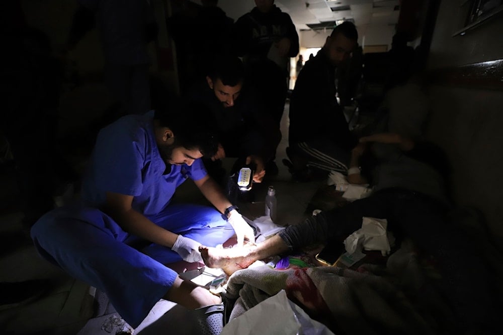 Palestinian medics treat the wounded using torchlights after running out of power at the Indonesian hospital in Beit Lahiya during Israeli bombardment of the northern Gaza Strip, Nov. 19, 2023. (AP)