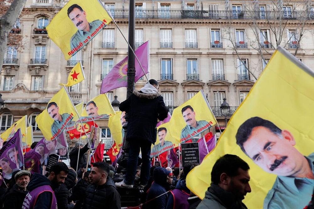 Kurdish activists hold a posters of jailed PKK leader Abdullah Ocalan during a protest in Paris, Saturday, Jan. 7, 2023. (AP)