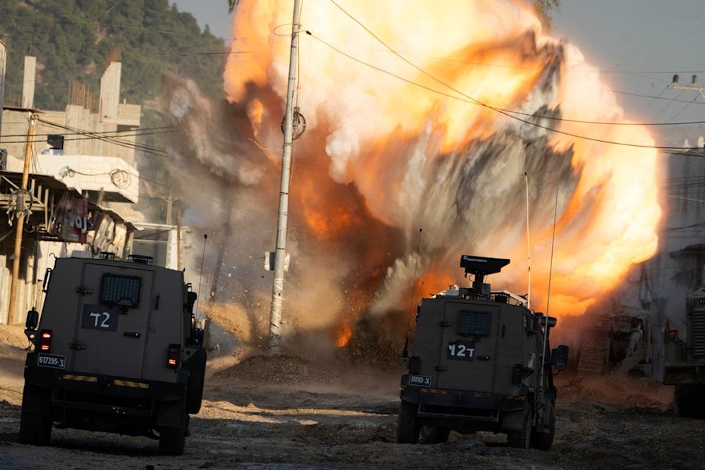 An explosive device planted by Palestinian Resistance fighters explodes after being detonated by Israeli soldiers during a raid in the Nur Shams refugee camp near the West Bank city of Tulkarm, Tuesday, December 24, 2024 (AP)