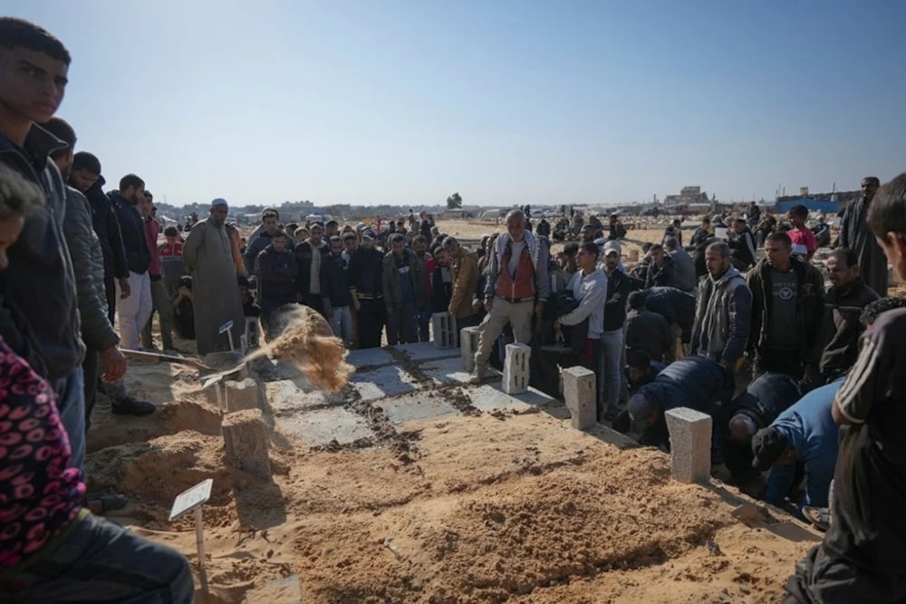 The grave of three Palestinian children from the same family killed during an Israemli army strike are covered during their burial in Khan Younis, November 2024. (AP)