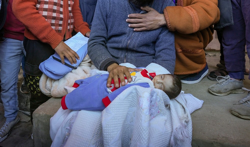 Yehia al-Batran grieves as he holds the body of his 20-day-old son Jomaa, who died from hypothermia, at Al-Aqsa Martyrs Hospital in central Gaza, Sunday, Dec. 29, 2024. (AP)