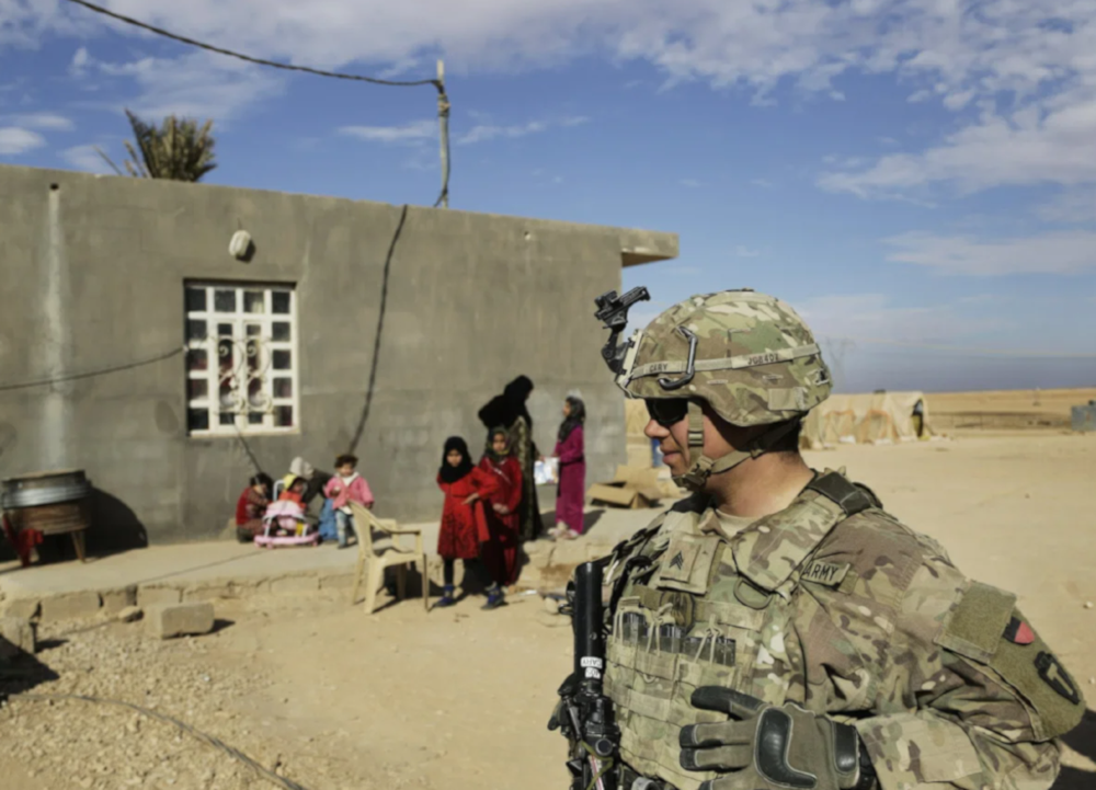 US Army soldier stands outside an Iraqi family home in al-Anbar in western Iraq on January 27, 2018 (AP)