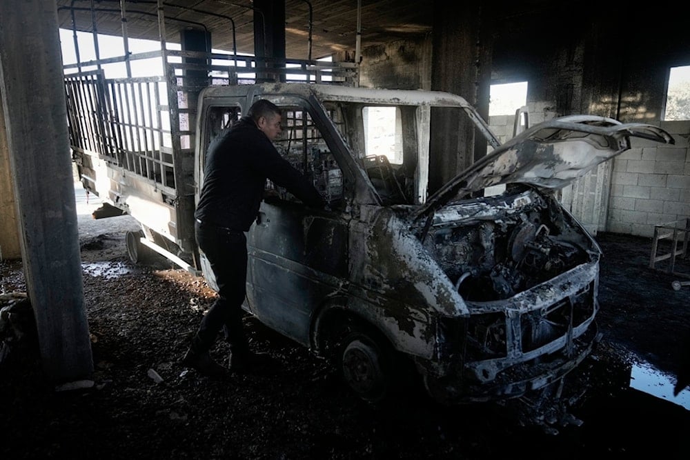 Mohammed Hanani looks at his burnt car following a settler attack that damaged vehicles and houses in the village of Beit Furik, in the occupied West Bank city of Nablus, Wednesday, Dec. 4, 2024. (AP)