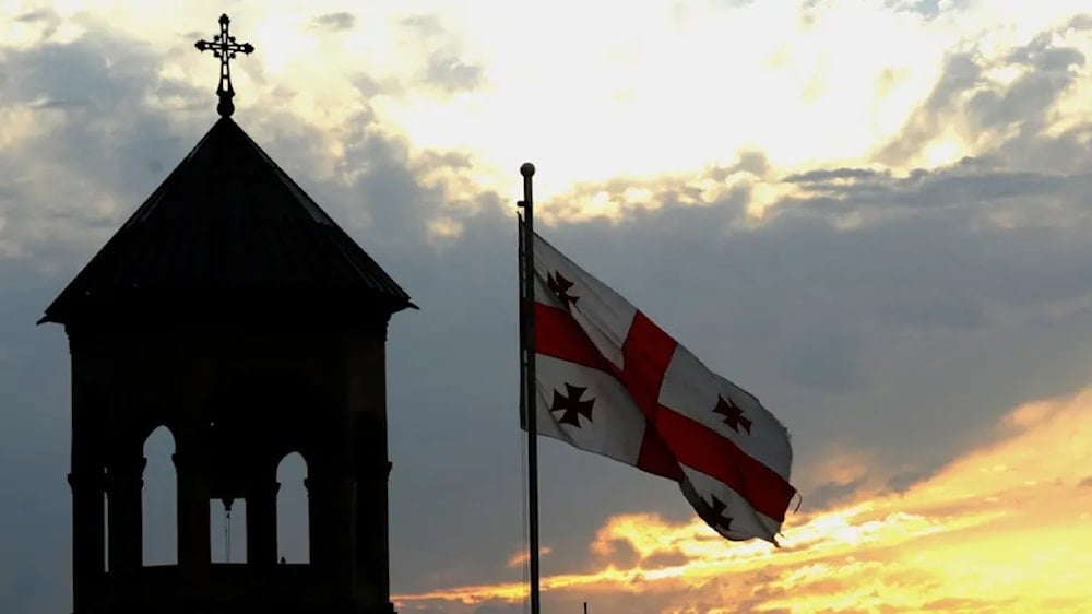 Flag of Georgia pictured next to a Georgian Orthodox church. (AFP)