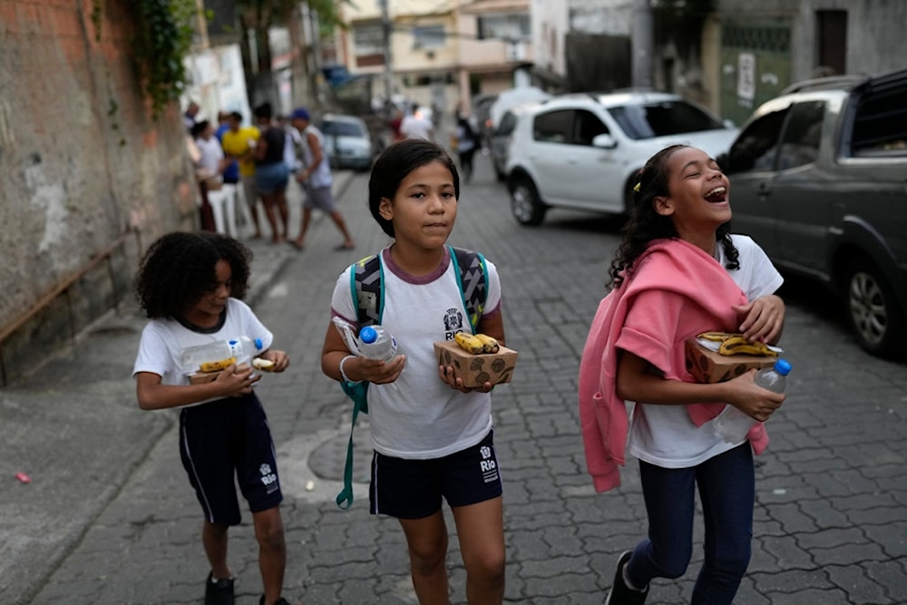 Children go to their home after getting food donated by a social project at Turano favela, Rio de Janeiro, Monday, June 17, 2024. (AP)