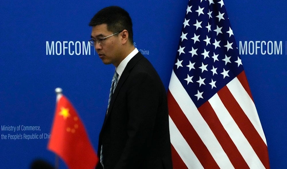 A Chinese official walks by the China and U.S. national flags before a meeting between Commerce Secretary Gina Raimondo and Chinese Minister of Commerce Wang Wentao at the Ministry of Commerce in Beijing on Aug. 28, 2023. (AP)