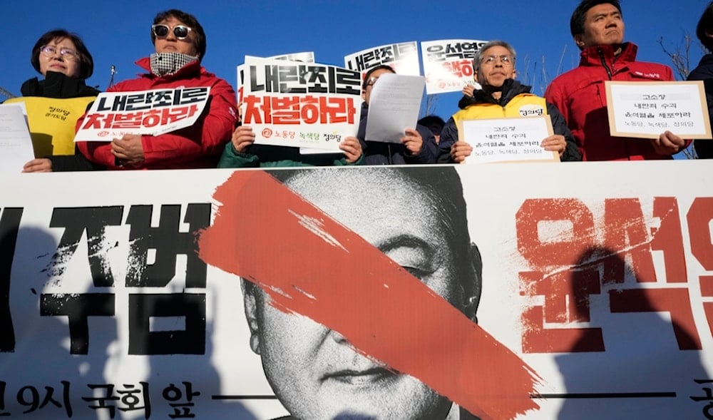 Protesters stage a rally to demand South Korean President Yoon Suk Yeol to step down in front of the National Assembly in Seoul, South Korea, Wednesday, Dec. 4, 2024. The signs read 