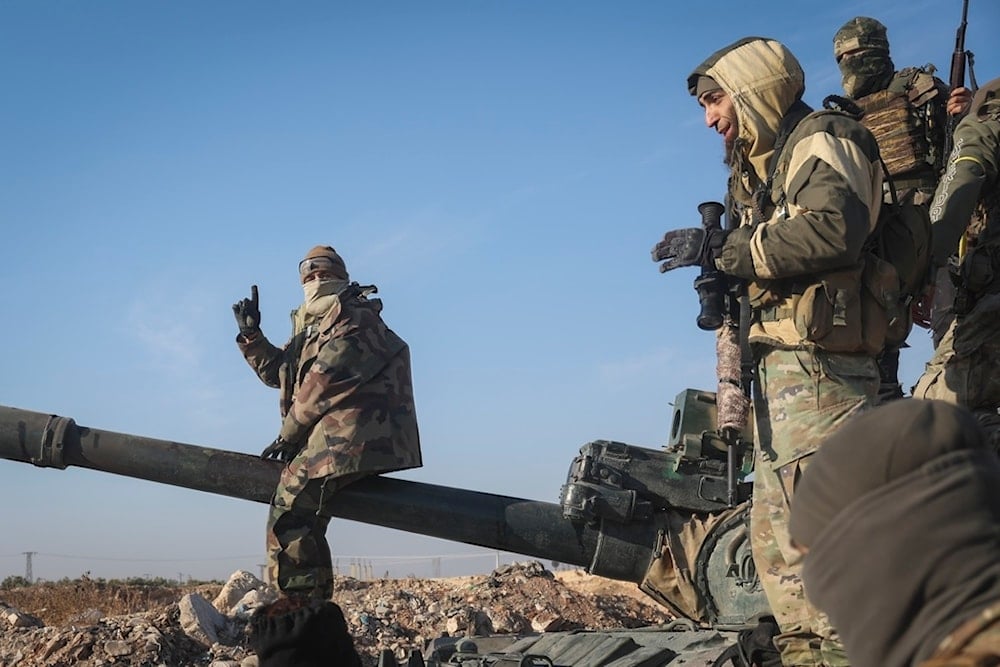 Syrian terrorists stand atop a seized Syrian army armoured vehicle in the outskirts of Hama, Syria, Tuesday Dec. 3, 2024. (AP)