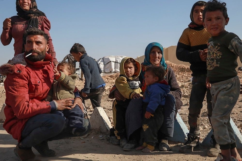 Internally displaced people sit in a camp in Tabqa city, Raqqa governorate, northern Syria, on Wednesday, December 4, 2024 (AP)