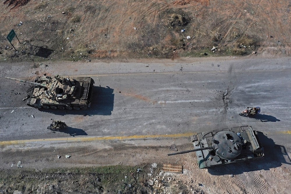 Syrian terrorists ride on motorcycles through abandoned Syrian army vehicles on a road in the outskirts of Hama, Syria, Dec. 3, 2024.(AP)