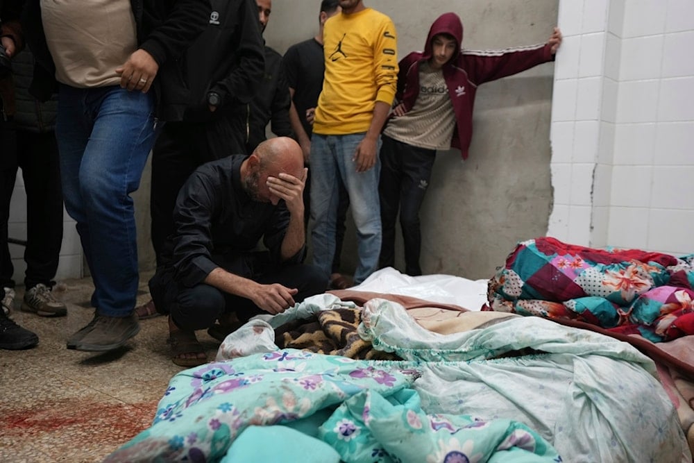 Palestinians mourn over relatives killed in an Israeli occupation bombardment in Nuseirat, central Gaza, as they stand in a hospital morgue in Deir al-Balah, Gaza Strip, Palestine, Nov. 20, 2024. (AP)