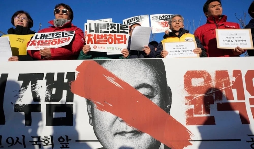 Protesters stage a rally to demand South Korean Presidenr Yoon Suk Yeol to step down in front of the National Assembly in Seoul, Wednesday Dec.4,2024. The signs read 