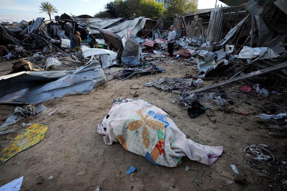 A body recovered earlier lies on the ground at the Muwassi camp near Khan Younis, in the southern Gaza Strip, on December 5, 2024. (AP)