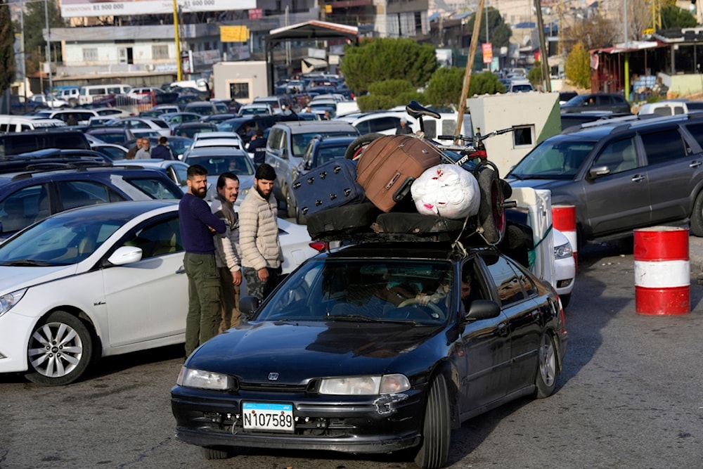 Syrians with their belongings queue as they cross to Syria through the Lebanese border crossing point of Masnaa, Bekaa Valley, Lebanon, Sunday, Dec. 8, 2024. (AP)