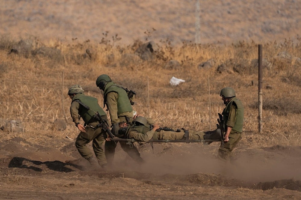 Israeli occupation soldiers carry a soldier on a stretcher during a drill as Israeli forces are stationed near the border with Lebanon, in occupied Palestine, Oct. 14, 2023. (AP)