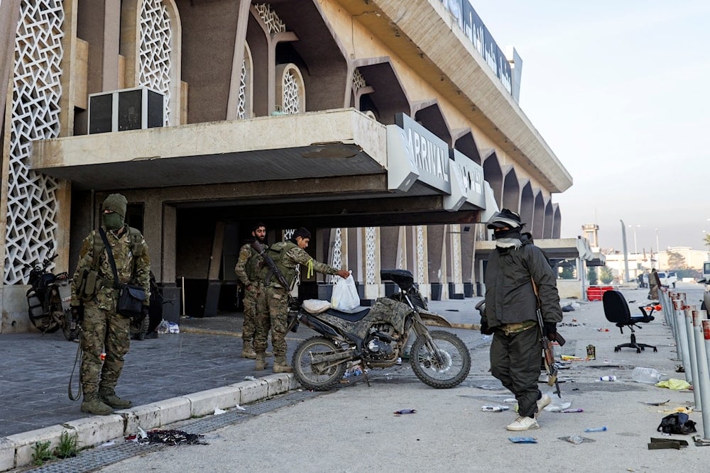 Syrian opposition fighters hang out at the arrivals gate of the Aleppo international airpot in Aleppo, Syria, on December 2, 2024. (AP)