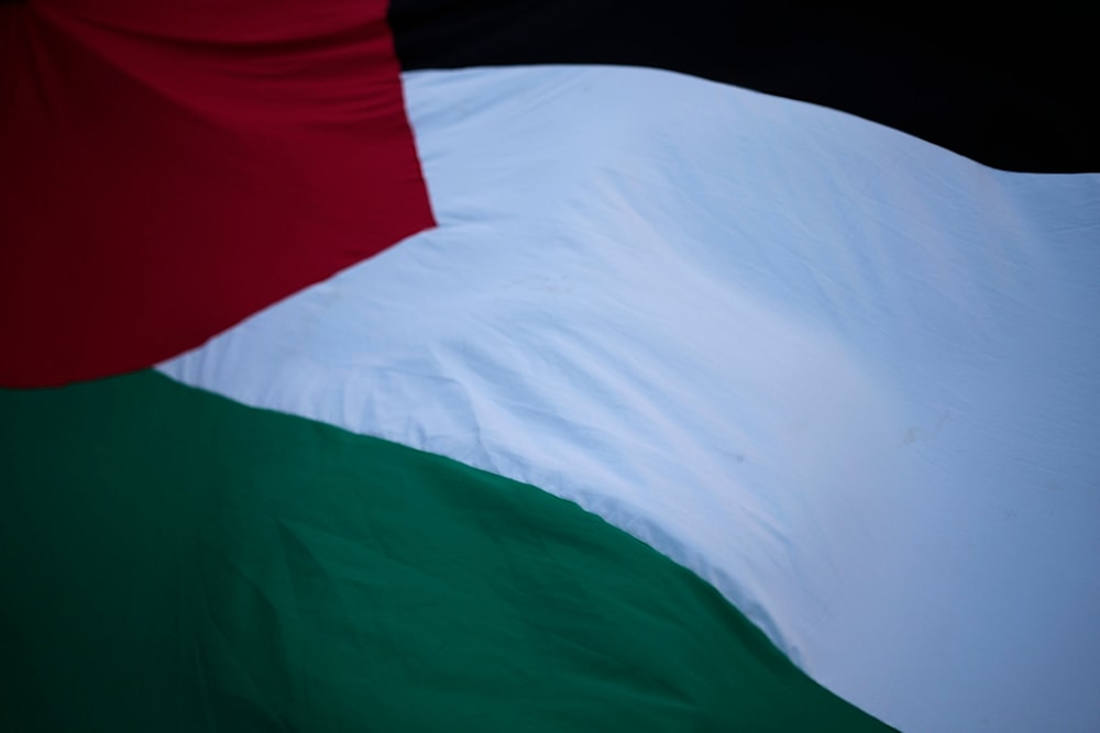 People flutter a Palestinian giant flag during a demonstration in support of the Palestinian people and demanding a cease fire in Gaza, in Lisbon, Friday, Dec. 8, 2023. (AP)