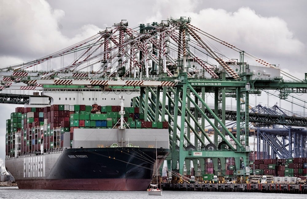 A sailboat passes a cargo ship unloading containers the port of Los Angeles in San Pedro on Thursday, June 15, 2023. (AP)