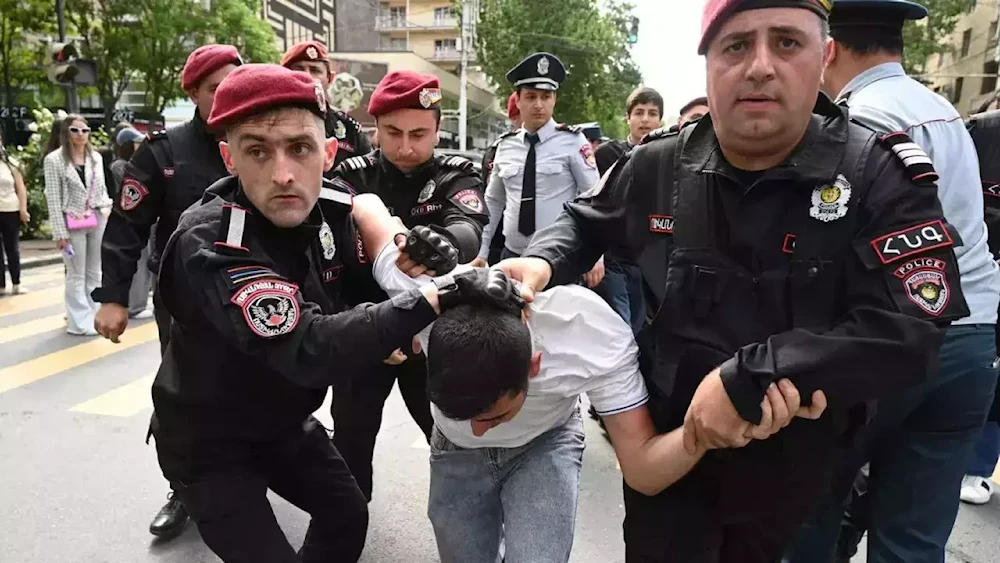 Armenian law enforcement officers detain a demonstrator in a protest against land transfer to Azerbaijan, in Yerevan, Armenia, on May 13, 2024. (AFP)