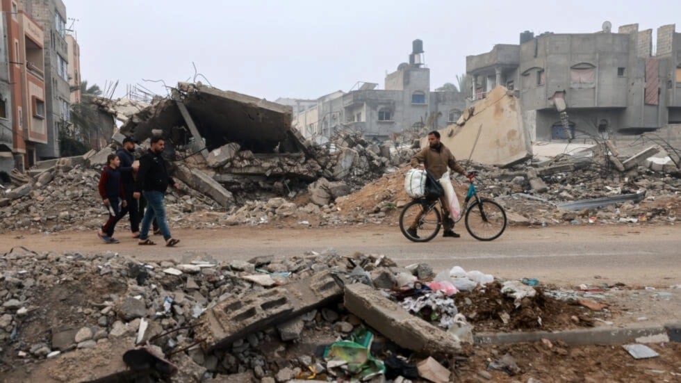 Men walk along a street ravaged by Israeli bombing in Rafah in the southern Gaza Strip on February 9, 2024, amid the ongoing Israeli genocide. (AFP)