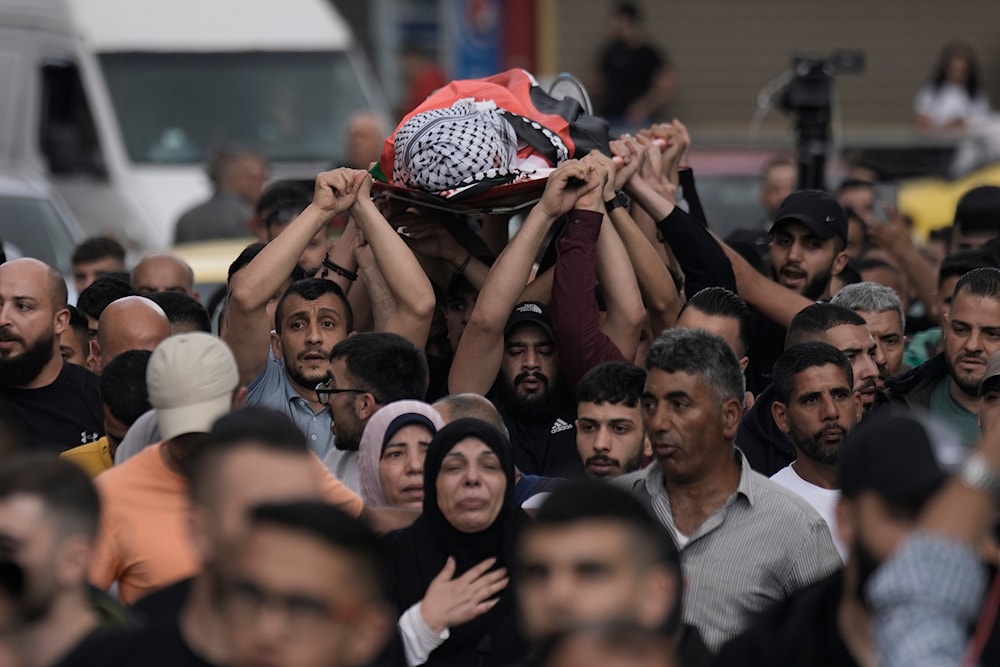 Mourners carry the body of Samer Rumaneh, draped in a Palestinian flag, who was killed in an Israeli military raid, during his funeral in the West Bank city of Nablus, Sunday, May 12, 2024. (AP)
