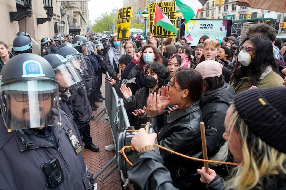 New York City police officers in riot gear stand guard as Pro-Palestinian students chant slogans outside the Columbia University campus in New York. (AP)