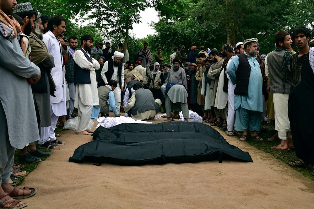 Dead bodies of Afghan people are placed on the ground after heavy flooding in Baghlan province in northern Afghanistan Saturday, May 11, 2024. (AP)