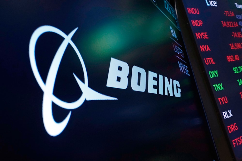 The logo for Boeing appears on a screen above a trading post on the floor of the New York Stock Exchange, July 13, 2021. (AP)