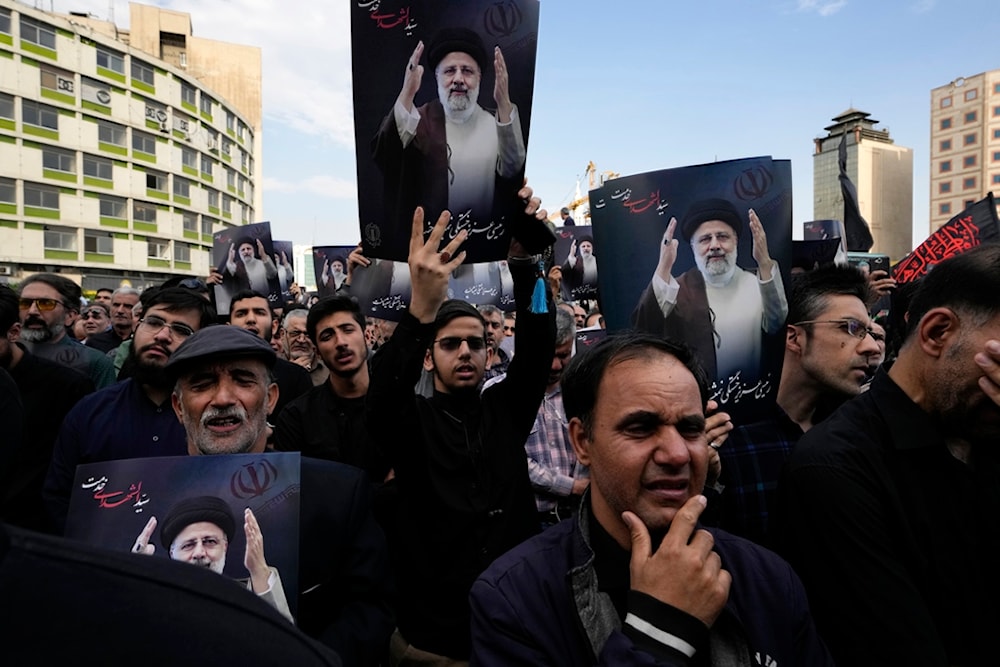 People hold up posters of Iranian President Ebrahim Raisi during a mourning ceremony for him at Vali-e-Asr square in downtown Tehran, Iran, Monday, May 20, 2024. (AP)