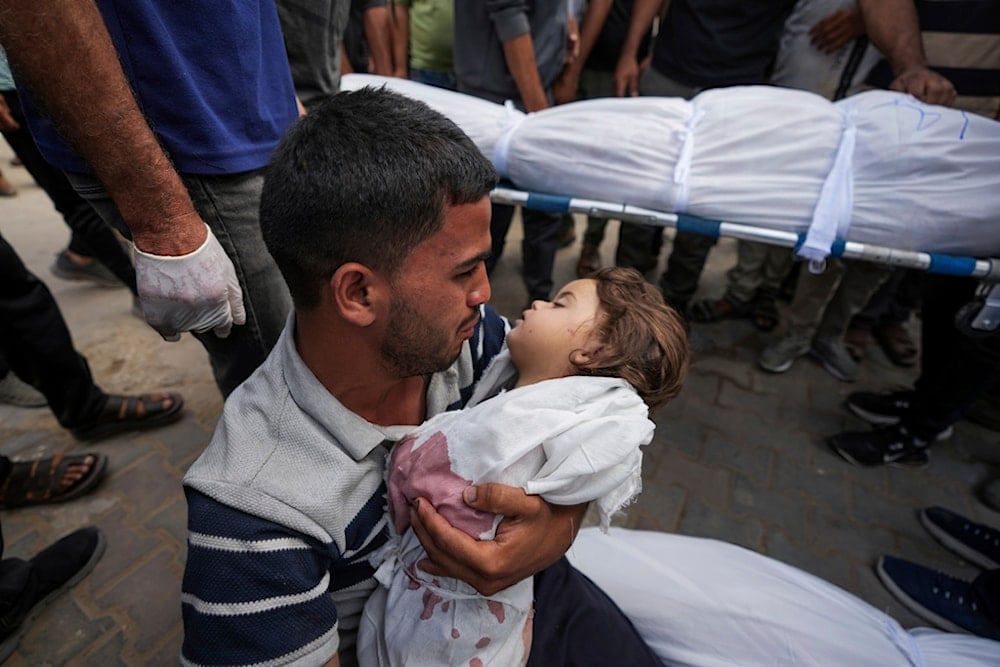 Karam Harara holds the body of his 2-year-old daughter Sabreen, who was among 20 people, mostly women and children, killed in an Israeli airstrike in central Gaza, Sunday, May 19, 2024. (AP)